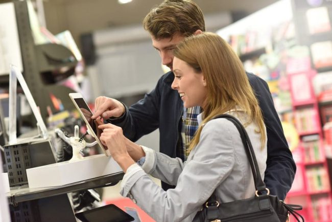 Couple in store choosing digital tablet Le Drive-to-store